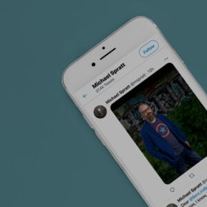 Close up of iPhone with Michael Spratt Twitter feed